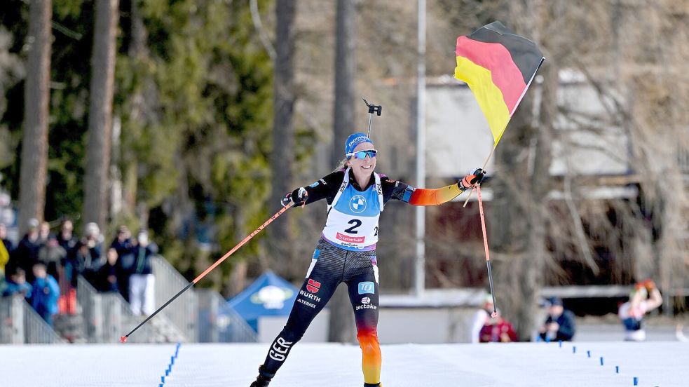 Franziska Preuß läuft mit der deutschen Fahne ins Ziel. Foto: Martin Schutt/dpa