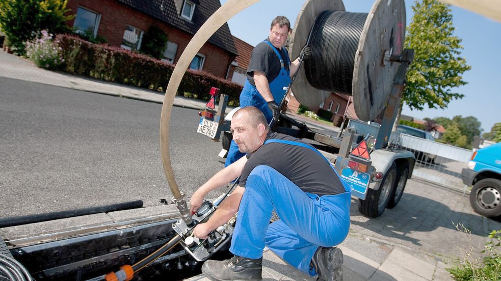 Glasfaser werden von EWE-Mitarbeitern in ein Kabel eingeblasen. Im Landkreis Leer geht der Breitbandausbau weiter. Foto: EWE/Archiv