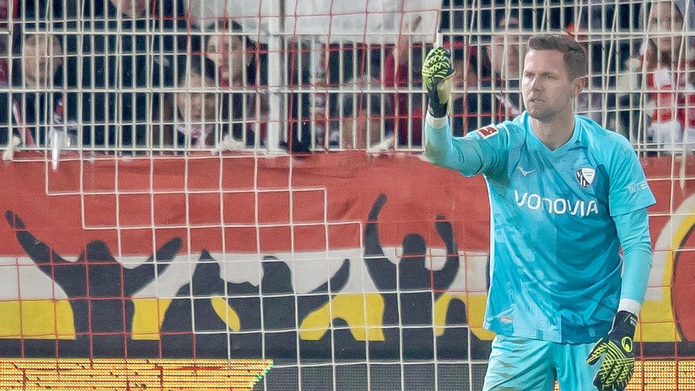 Bochums Keeper Patrick Drewes hält das Feuerzeug hoch, das ihn getroffen hat. Foto: Andreas Gora/dpa