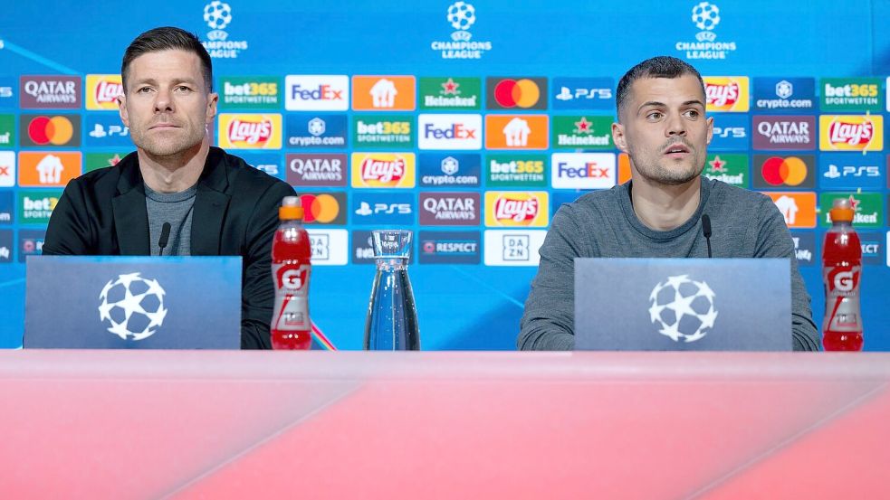 Trainer Xabi Alonso (l) und Granit Xhaka äußern sich bei der Pressekonferenz in der Allianz Arena zur Problematik möglicher Gelb-Sperren. Foto: Sven Hoppe/dpa