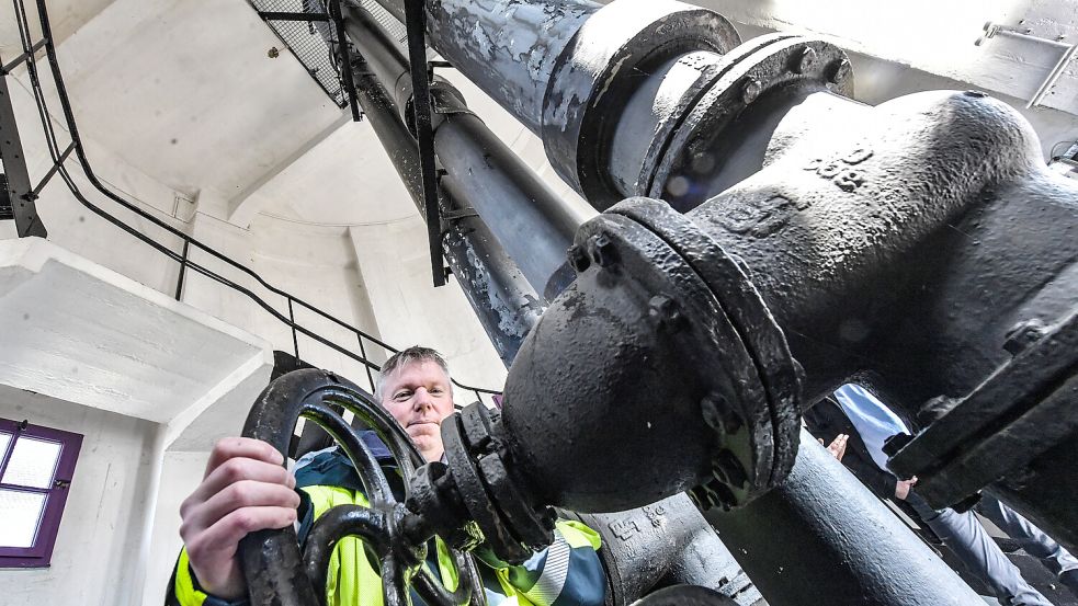 Stadtwerke-Wassermeister Ralf Oelrichs demonstriert, wie der Schieber die Zuleitung zum Wasserturm unterbinden kann. Das muss noch manuell gesteuert werden. Normalerweise wird nur einmal im Jahr zur Inspektion das Wasser aus dem großen Behälter ganz oben im Turm abgelassen, für die Sanierung wird der Turm bis Ende 2026 außer Dienst gestellt. Fotos: Ortgies