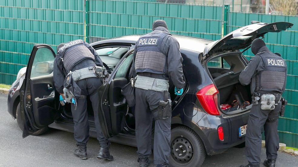 Nach Sonderzug-Gewalt: Polizeibeamte durchsuchen mehrere Pkw vor einem Wohnhaus. Foto: Christoph Reichwein/dpa