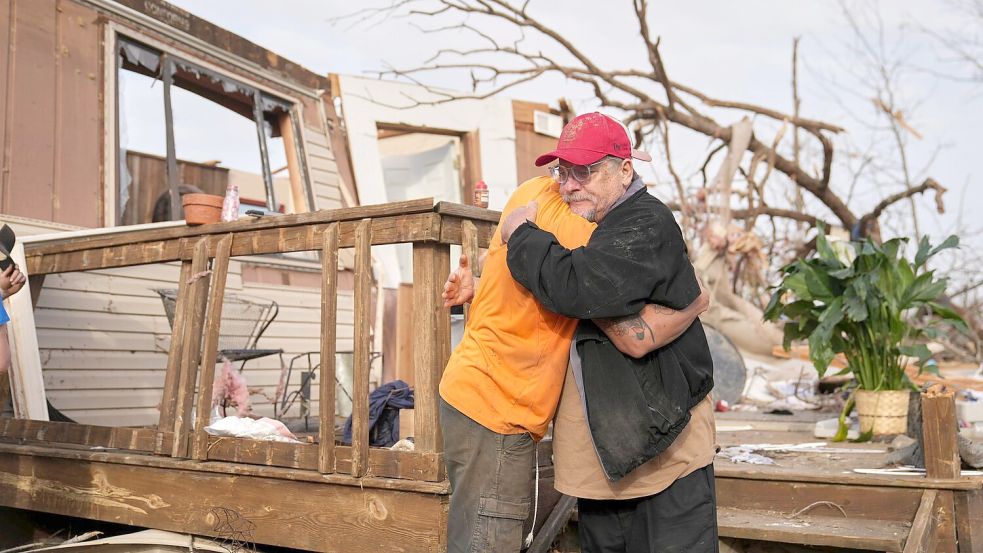 Nach dem Durchzug eines Tornados in Missouri spenden sich Freunde Trost und räumen auf. Foto: Jeff Roberson/AP/dpa