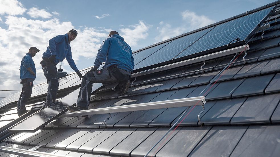 Module einer Solaranlage werden auf einem Dach montiert. Foto: DPA