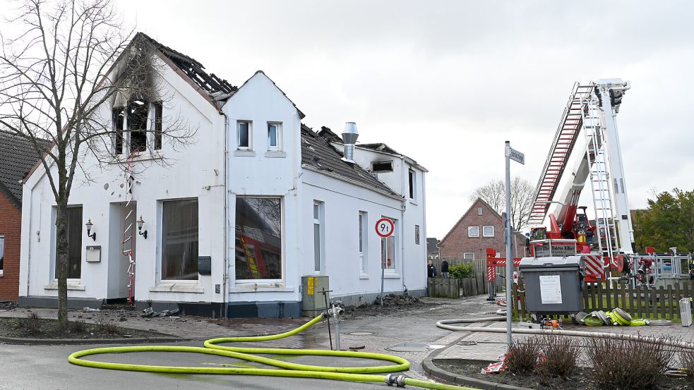 Eine Drehleiter der Feuerwehr steht vor dem ausgebrannten Haus in Bunde. Darin waren zehn Monteure aus der Slowakei untergebracht. Foto: Lars Penning/dpa