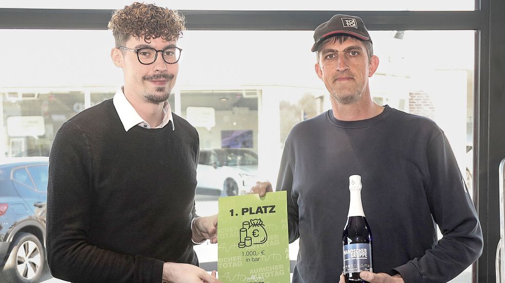 Glückwunsch zum ersten Preis: Kris Stubbe, Hauptorganisator des Autotags, überreicht Philipp Onken aus Großefehn den 1000-Euro-Hauptpreis. Foto: Romuald Banik