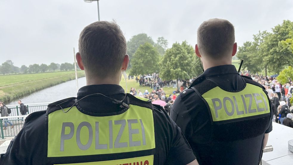 Vom Balkon des Schleusenwärterhäuschens blicken zwei Einsatzkräfte der Polizei auf die Feiernden. Foto: Christin Wetzel